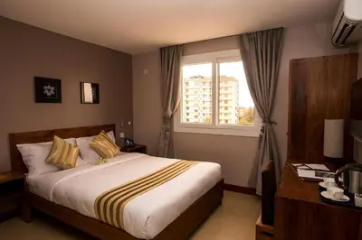 a bedroom with a large bed and a window at Venus Premier Hotel in Arusha
