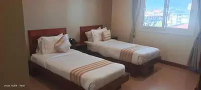a hotel room with two beds and a window at Venus Premier Hotel in Arusha