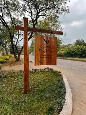 a wooden sign on the side of a road at Brubru Lodge in Moshi