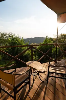 two chairs and a table on a wooden deck at Pembeni Rhotia in Karatu