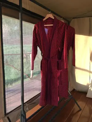 a red plaid suit hanging in a tent at Pembeni Rhotia in Karatu