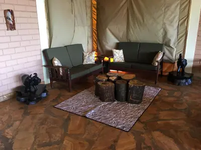 a living room with two chairs and a table at Pembeni Rhotia in Karatu