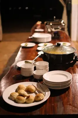 a long table with plates of food on it at Pembeni Rhotia in Karatu