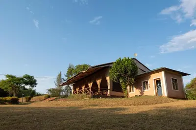 a small house in a field with a tree next to it at Pembeni Rhotia in Karatu