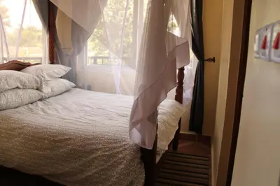 a bedroom with a bed and a window at East Point Hotel Moshi in Moshi