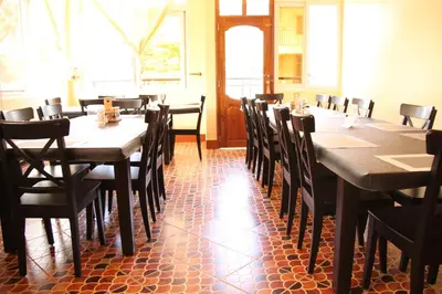 a dining room with wooden tables and chairs at East Point Hotel Moshi in Moshi