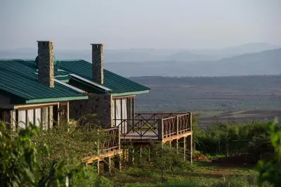 a house with a deck and a green roof at Ngorongoro Oldeani Mountain Lodge in Oldeani