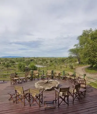 a group of tables and chairs on a deck at Mbali Mbali Tarangire River Camp in Kwa Kuchinia