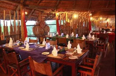 a dining room with tables and chairs in a room at Mbali Mbali Tarangire River Camp in Kwa Kuchinia