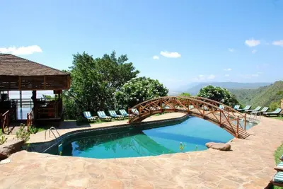 a wooden bridge over a pool in a backyard at Lake Manyara Wildlife Lodge in Mto wa Mbu