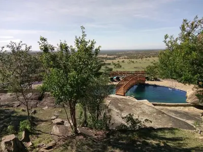 a bridge over a body of water with trees at Lobo Wildlife Lodge in Serengeti