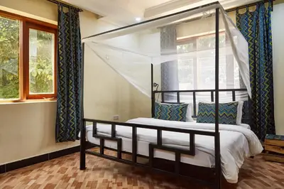 a bedroom with a canopy bed and a window at Viva Tanzania in Arusha