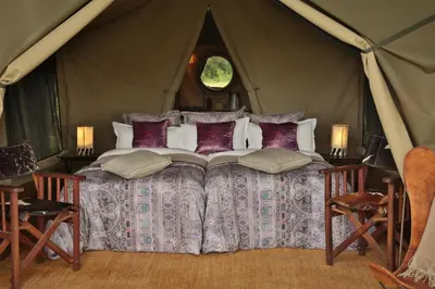 a bedroom with a bed in a tent at Pakulala Safari Camp - Ngorongoro in Ngorongoro