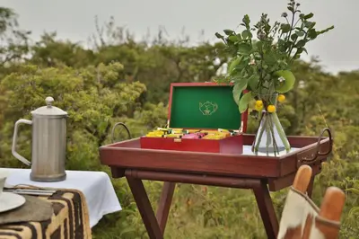 a table with a tray with a vase of flowers at Pakulala Safari Camp - Ngorongoro in Ngorongoro