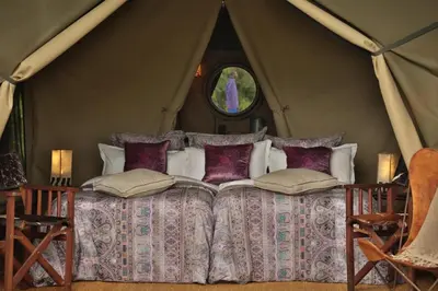 a bedroom with a bed in a tent at Pakulala Safari Camp - Ngorongoro in Ngorongoro