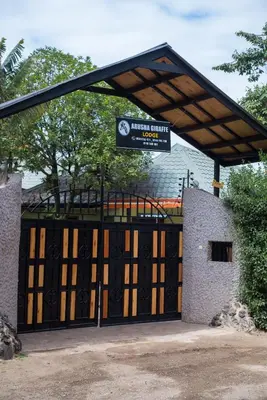 a black gate with a sign on top of it at Arusha Giraffe Lodge in Arusha