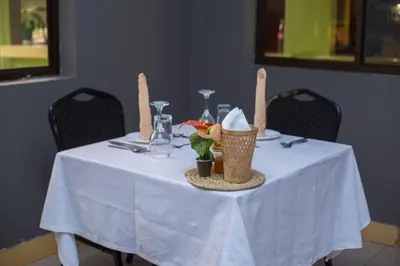 a table with a white table cloth on it at Arusha Giraffe Lodge in Arusha