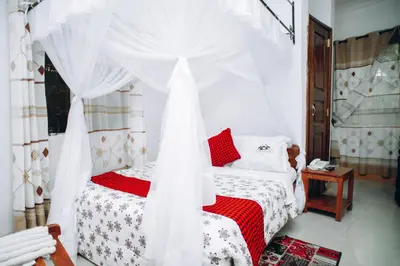a bedroom with a bed with a canopy at Arusha Giraffe Lodge in Arusha