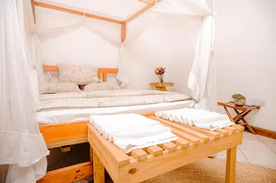 a bedroom with two beds and a table with towels at City Villa in Arusha