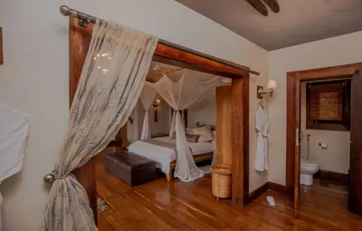 a bedroom with a bed with a canopy at Escarpment Luxury Lodge Manyara in Mto wa Mbu