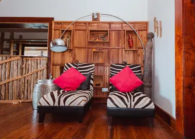 two chairs with red pillows in a living room at Escarpment Luxury Lodge Manyara in Mto wa Mbu