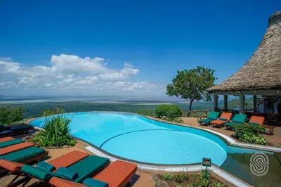 a swimming pool with chairs and a gazebo at Lake Manyara Serena Safari Lodge in Karatu