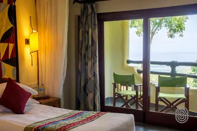 a bedroom with a bed and a view of the ocean at Lake Manyara Serena Safari Lodge in Karatu