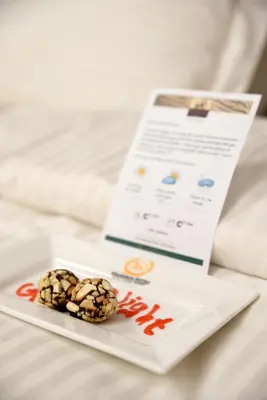 two donuts on a plate on a bed at Lake Manyara Kilimamoja Lodge in Mto wa Mbu