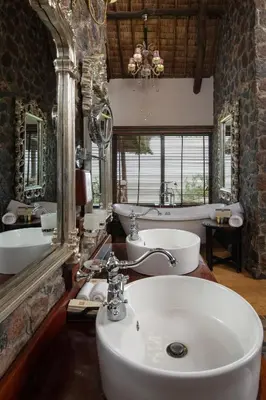 a bathroom with a sink and two sinks and a tub at Lake Manyara Kilimamoja Lodge in Mto wa Mbu