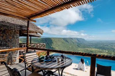 a view from the balcony of a house with a table and chairs at Lake Manyara Kilimamoja Lodge in Mto wa Mbu