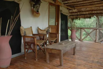 a living room with chairs and a wooden table at Roika Tarangire Tented Lodge in Kwa Kuchinia