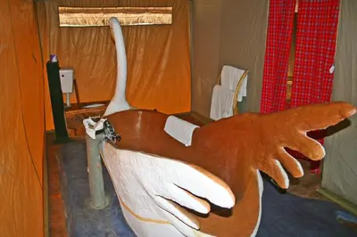 a wooden statue of a person holding at Roika Tarangire Tented Lodge in Kwa Kuchinia