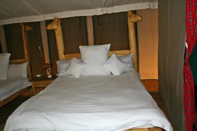 a bed with white sheets and pillows in a tent at Roika Tarangire Tented Lodge in Kwa Kuchinia