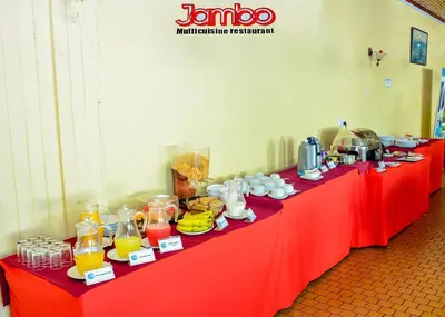 a long red table with drinks and food on it at Keys Hotel in Moshi