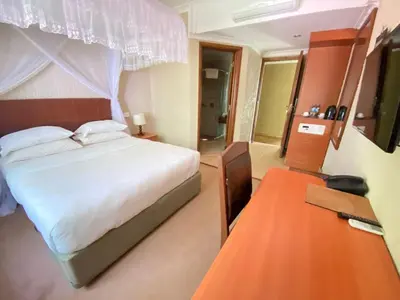 a hotel room with a bed and a table at Sangana Lodge in Moshi