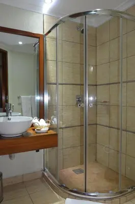 a bathroom with a shower and a sink at Sangana Lodge in Moshi