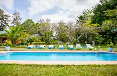 a swimming pool with lounge chairs and a group oficans at Meru View Lodge in Usa River