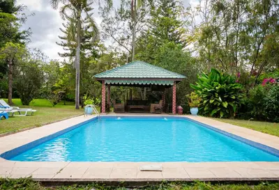 a swimming pool in a yard with a gazebo at Meru View Lodge in Usa River