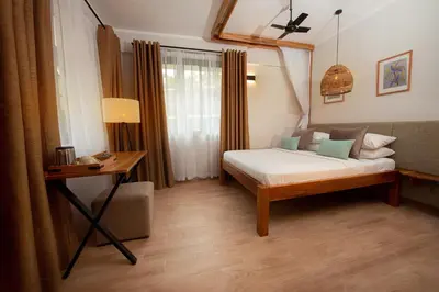 a bedroom with a bed and a table and a desk at Aishi Machame in Moshi