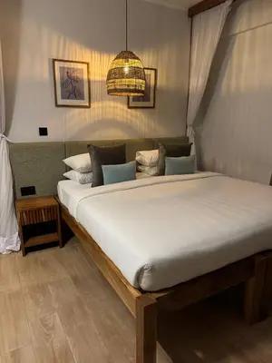 a large white bed in a bedroom with a chandelier at Aishi Machame in Moshi