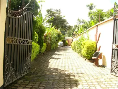 a cobblestone street with a black gate on a house at Bright Star Hotel & Safaris in Arusha