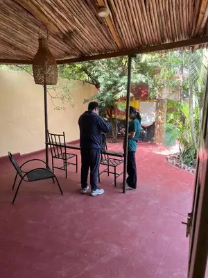 two men standing near a table and chairs on a patio at The Paradise Inn Kilimanjaro in Moshi