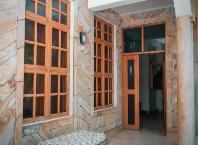 a room with wooden doors and a bench in a building at The Paradise Inn Kilimanjaro in Moshi