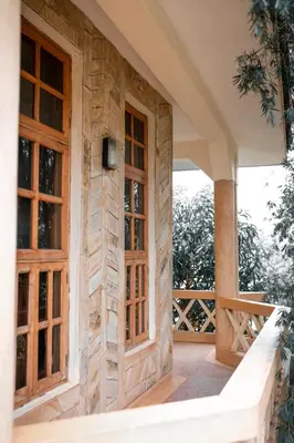 a house with wooden doors on a porch at The Paradise Inn Kilimanjaro in Moshi