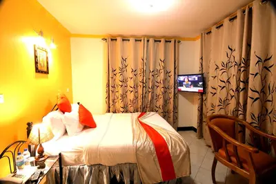a hotel room with a bed and a television at Crest Safari Lodge Bed and Breakfast in Arusha