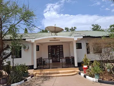 a white house with a revolving door at Rainbow Executive Lodge in Boma la Ngombe