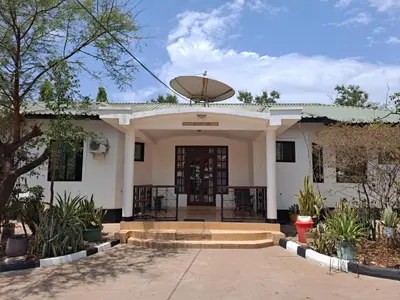a white house with a revolving door at Rainbow Executive Lodge in Boma la Ngombe