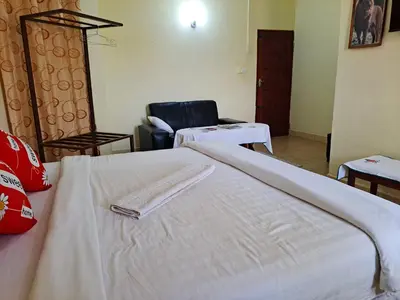 a hotel room with a bed and a chair at Rainbow Executive Lodge in Boma la Ngombe