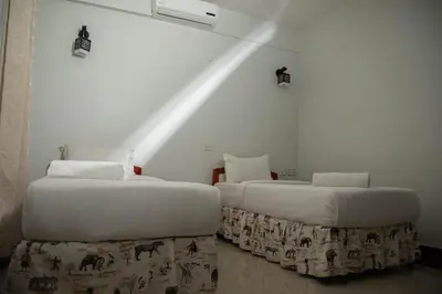 two beds sitting next to each other in a room at Panama Garden Resort in Moshi