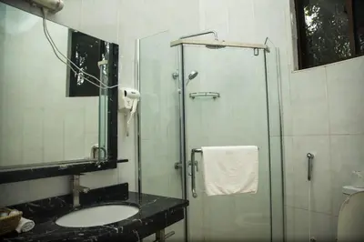 a bathroom with a glass shower and a sink at Panama Garden Resort in Moshi